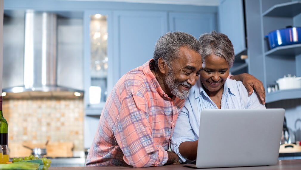Senior couple submitting application online.